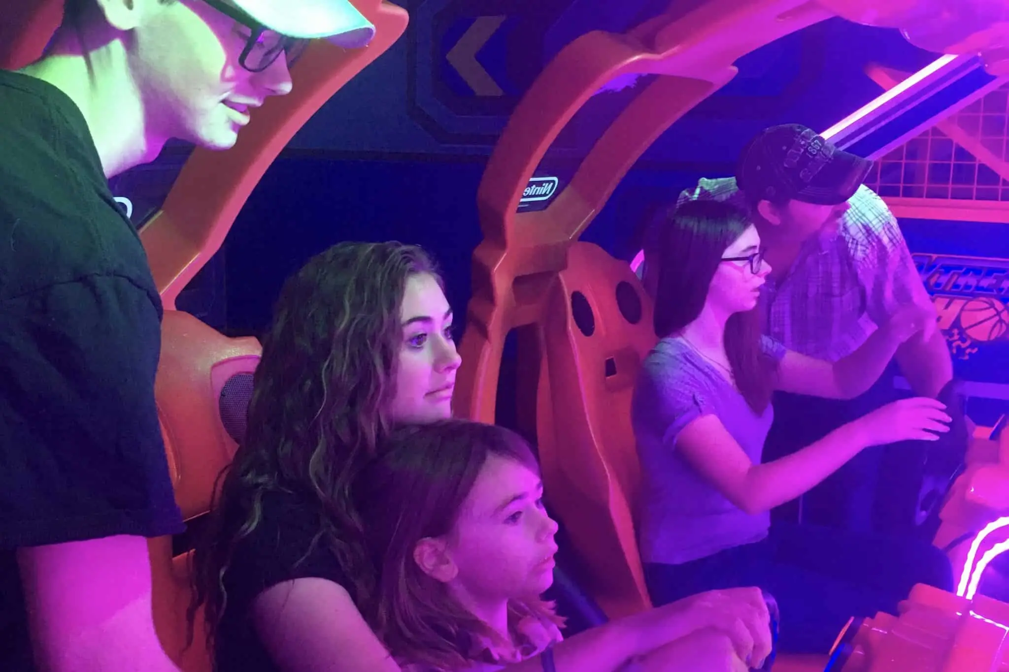 Family playing simulated racing games at Prairie Jurassic Laser Tag and Arcade