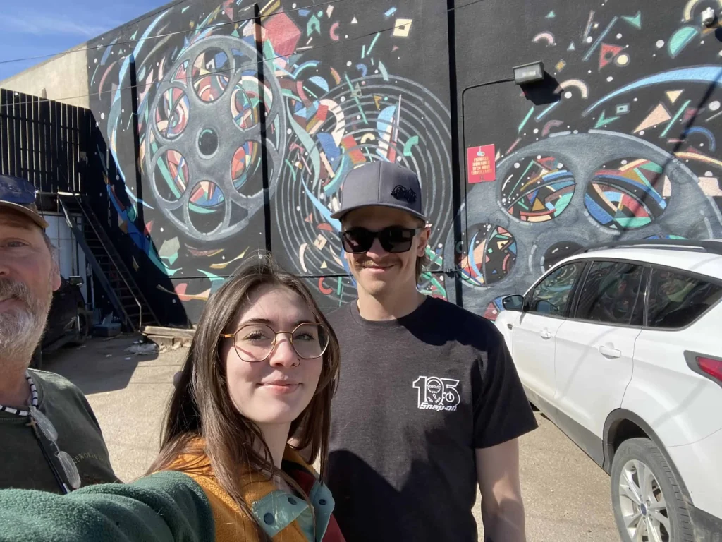 Family posing in front of colourful Broadway Avenue murals in Saskatoon during a self-guided scavenger hunt adventure