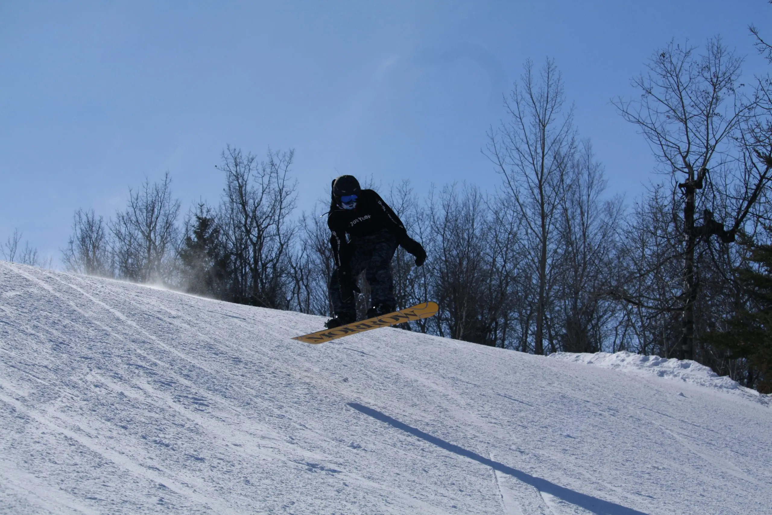 Snowboarder catching air on a snowy slope at Table Mountain ski area in Saskatchewan.
