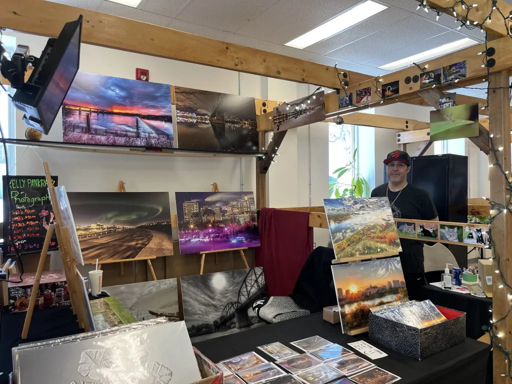 Photography booth at a Saskatoon farmer’s market displaying prairie, city, and northern landscape prints.