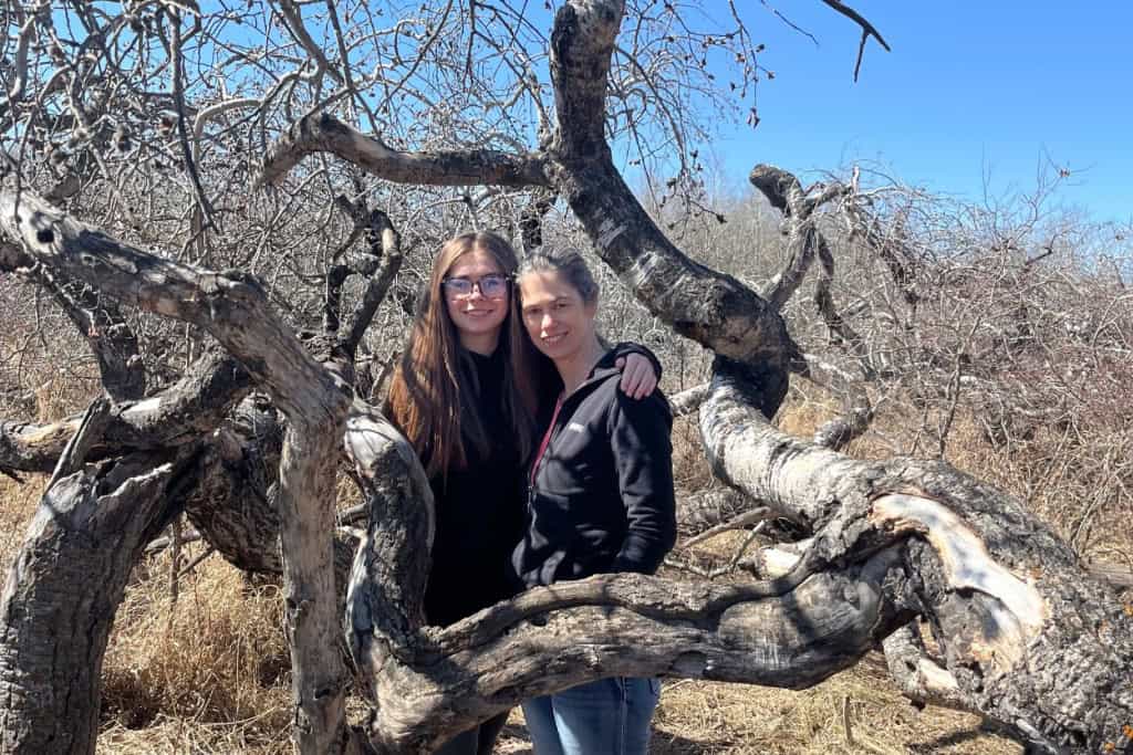 The Crooked Bush Sarah and Jen standing in the middle of a twisted and gnarled tree