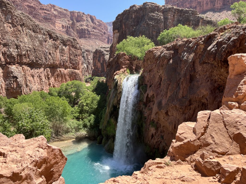 Havasu Falls falling over the canyon walls into the turquoise blue pool below