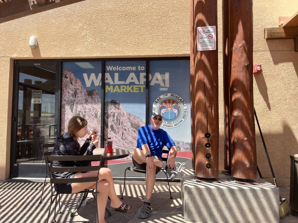 Sarah and Craig sitting on a patio in front of the Walapai Market