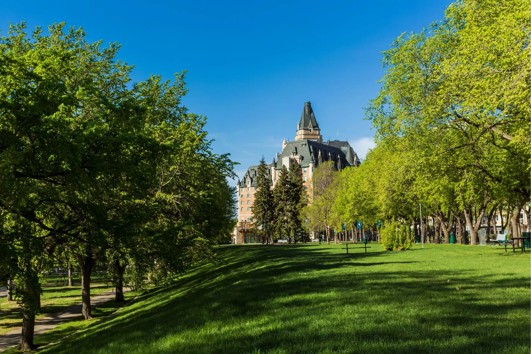 Where to Stay in Saskatoon Kiwanis Park in Saskatoon with a view of the Delta Bessborough Hotel in summer.