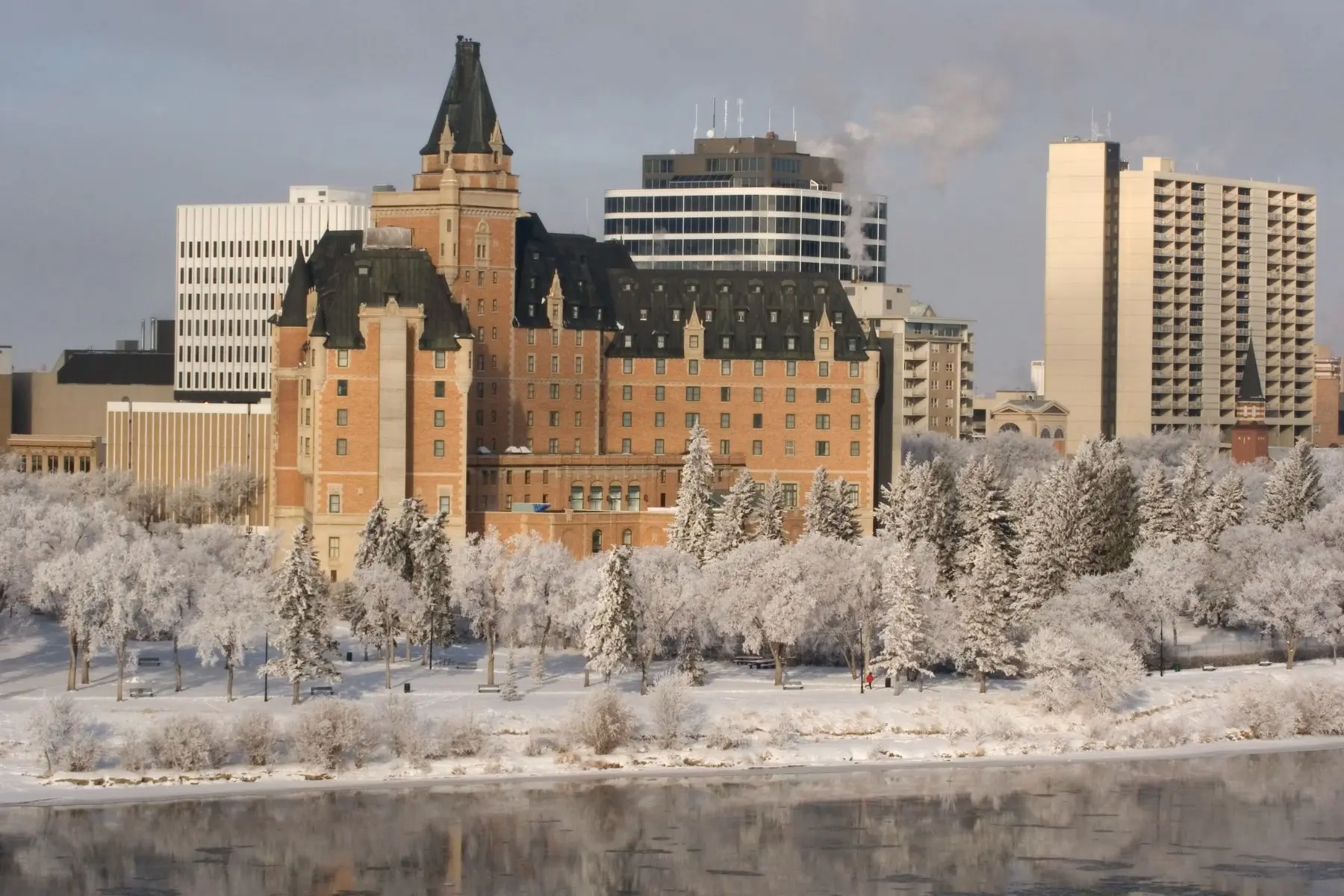 Where to Stay in Saskatoon Winter view of the Delta Bessborough Hotel along the South Saskatchewan River in Saskatoon.