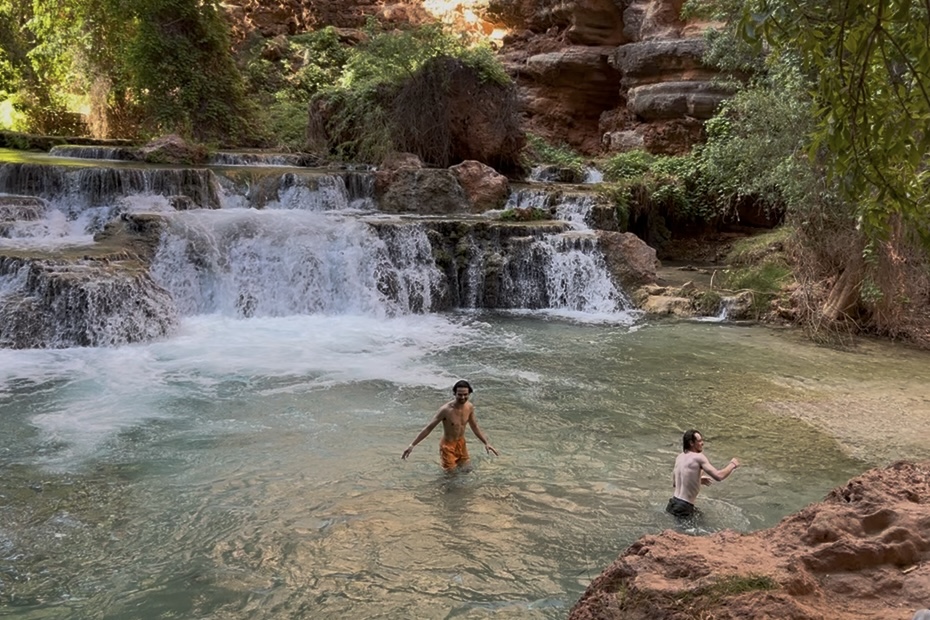 Beaver Falls Daniel and Joshua cooling off in the Havasu Creek with cascading travertine falls in the background