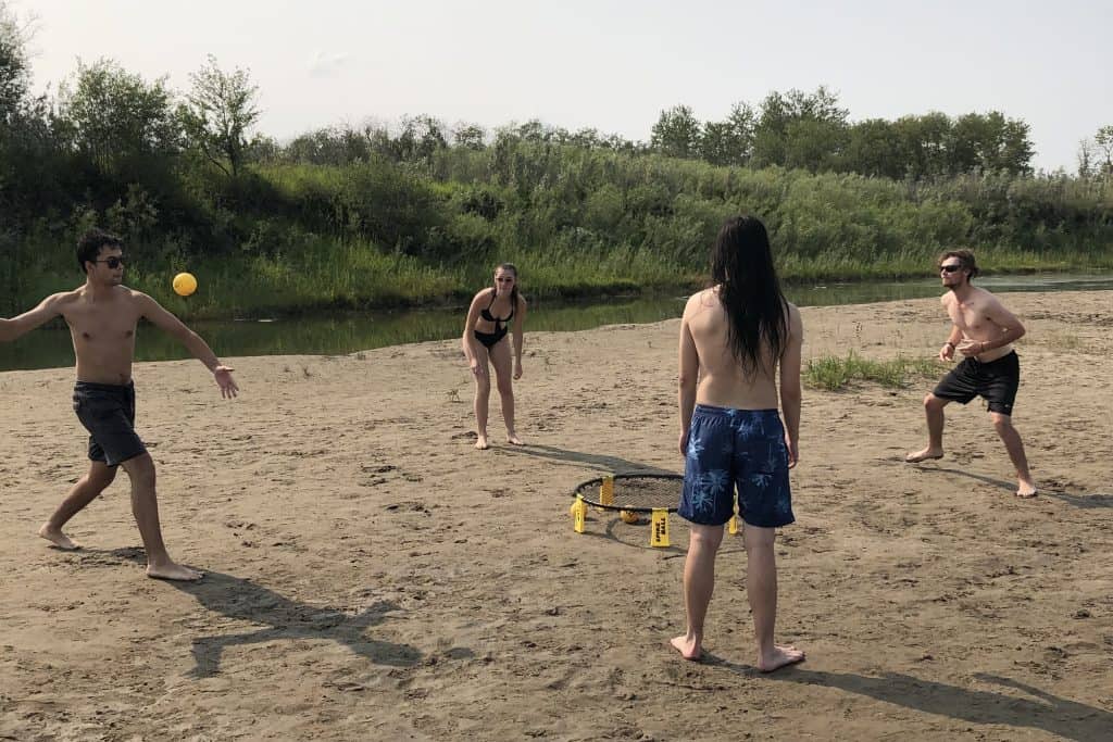 free things to do in Saskatoon Joshua, Jaimie, Daniel, and a friend playing a friendly game of Spikeball on the sandbar at Poplar Bluffs