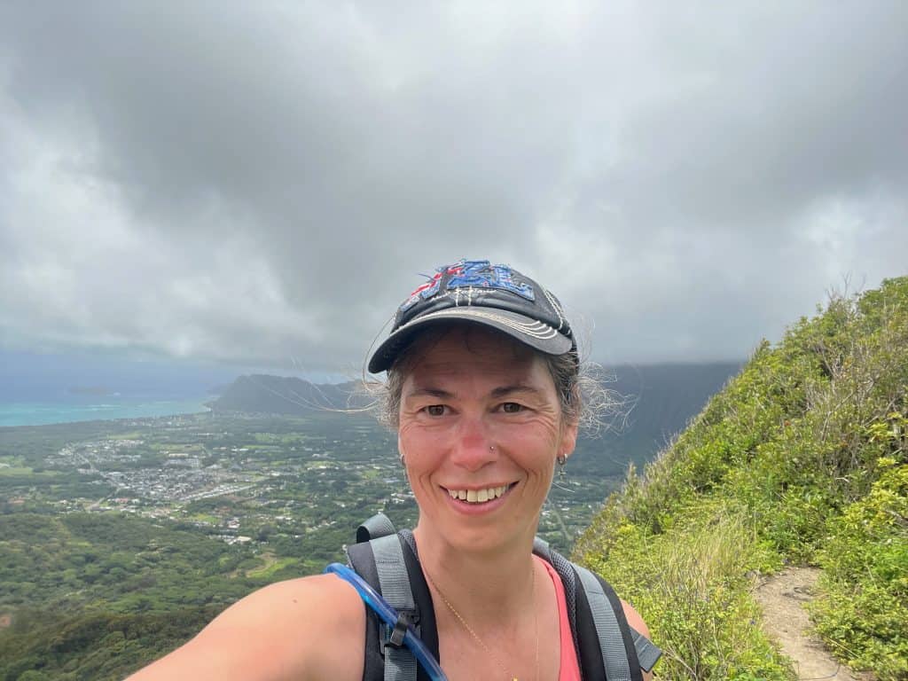 Hiker at the top of Peak two with a view of Oahu's Windward side in the background.