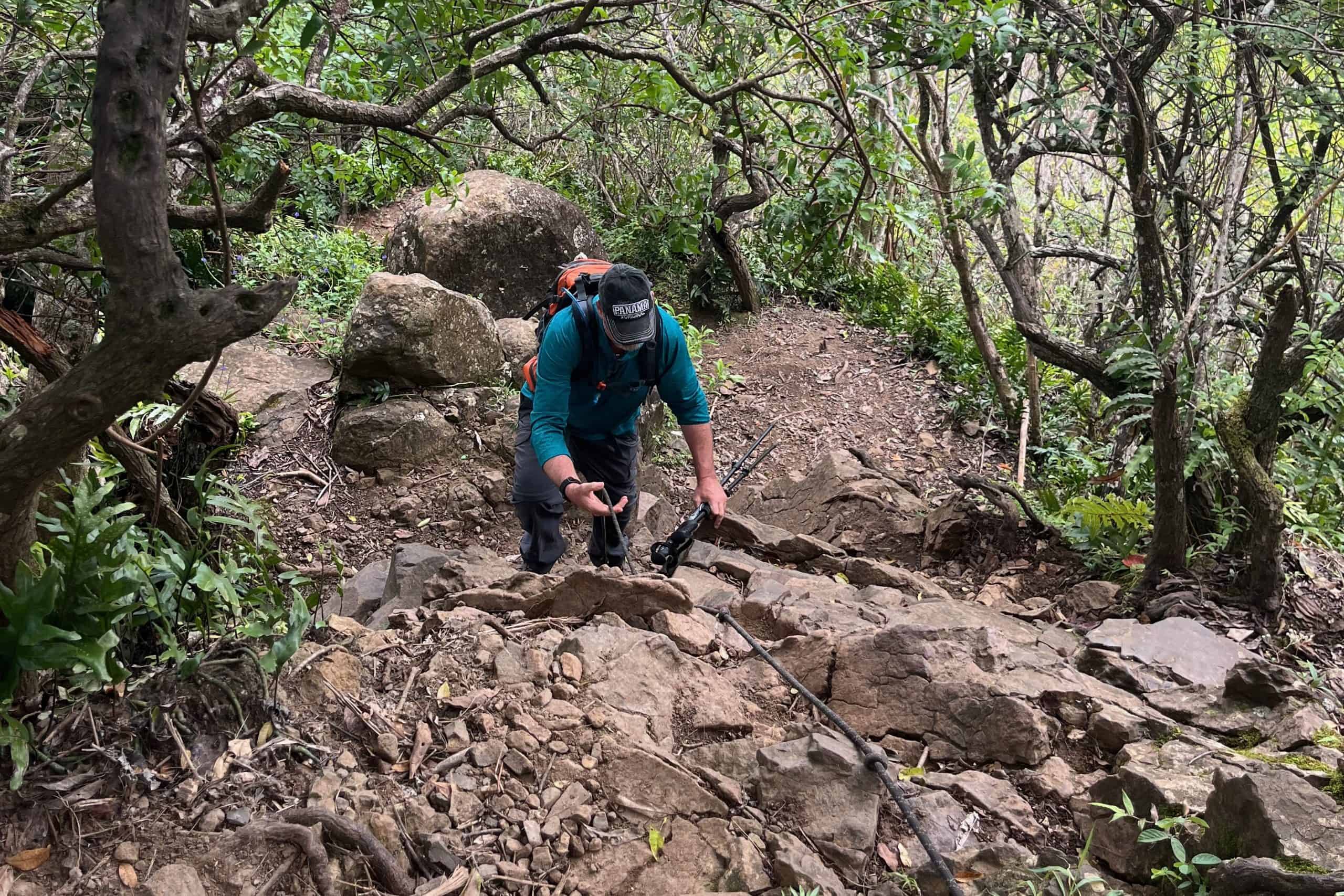 Hiker climbing the first rope section on the way to the first peak.