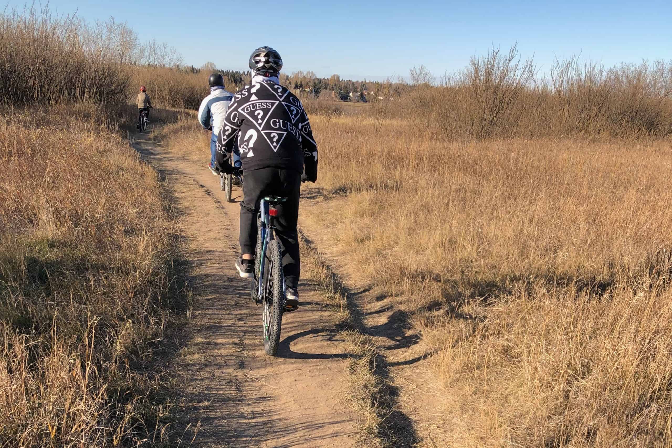 Cyclists riding along a dirt section of the Meewasin Trail in Saskatoon.