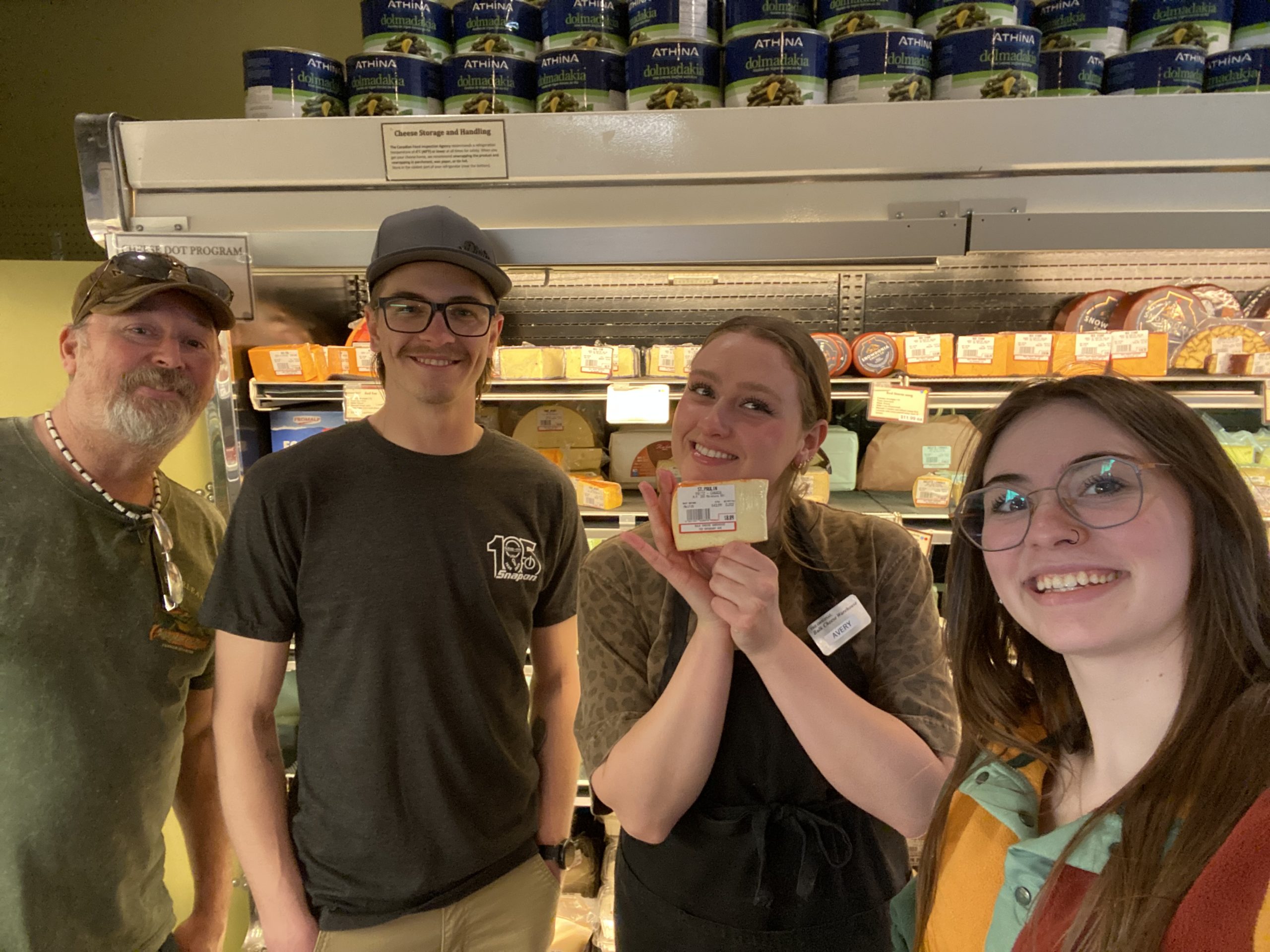 Free things to do in Saskatoon Jaimie and Craig with an employee at the Bulk Cheese Warehouse while completing the free scavenger hunt