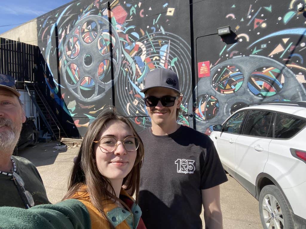Family posing in front of colourful Broadway Avenue murals in Saskatoon during a self-guided scavenger hunt adventure