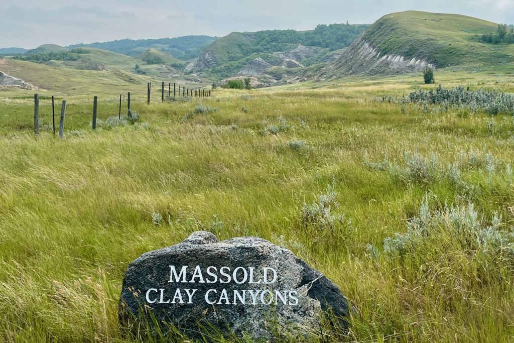 Big Muddy Badlands saskatchewan Large Rock with Masold Clay Canyon inscription, in a field with the Claybank Badlands in the background
