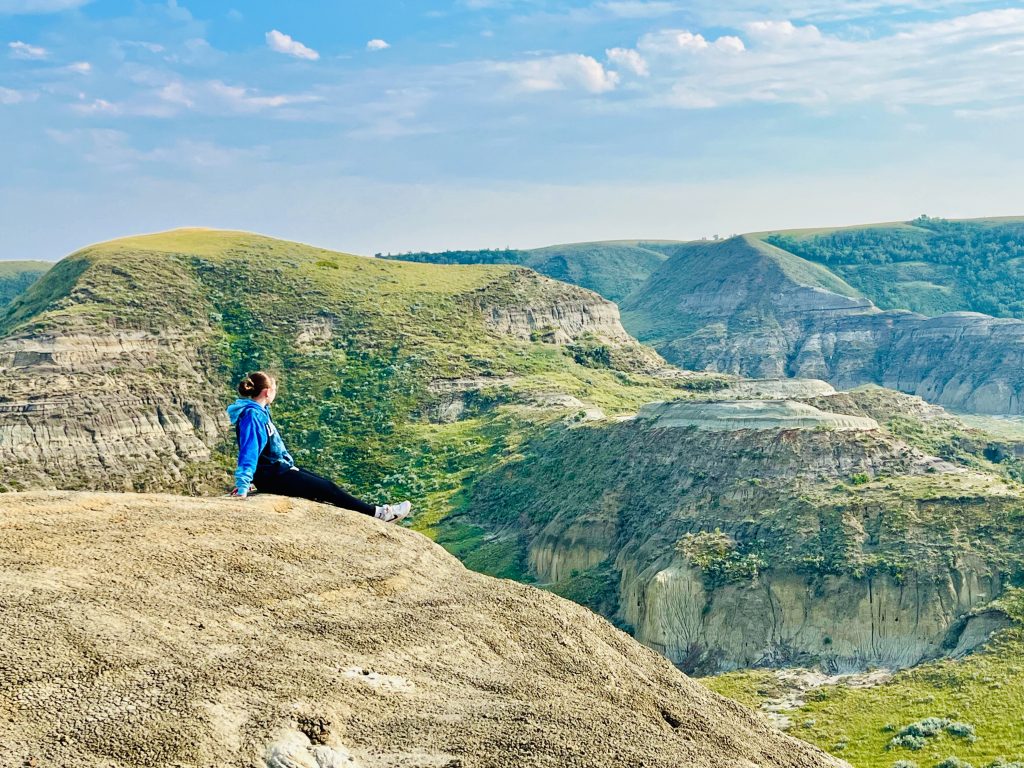Big Muddy Badlands Saskatchewan Sarah sitting on top of Castle Butte, looking out over Saskastchewan's Big Muddy Badlands