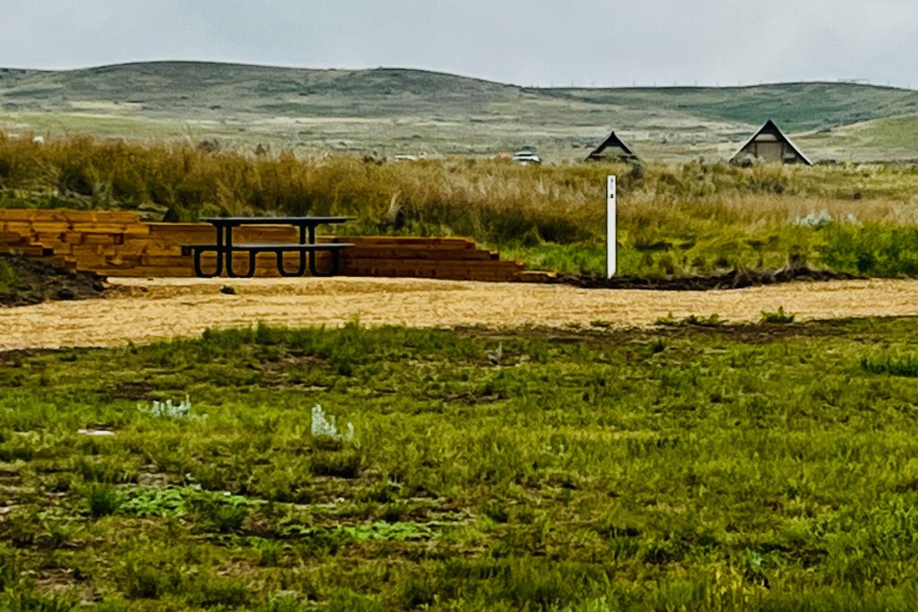 Valley of 1000 Devils Campsite at Rock Creek Campground with the peaks of the oTENTiks, rolling hills, and wild grasses in the backgroud