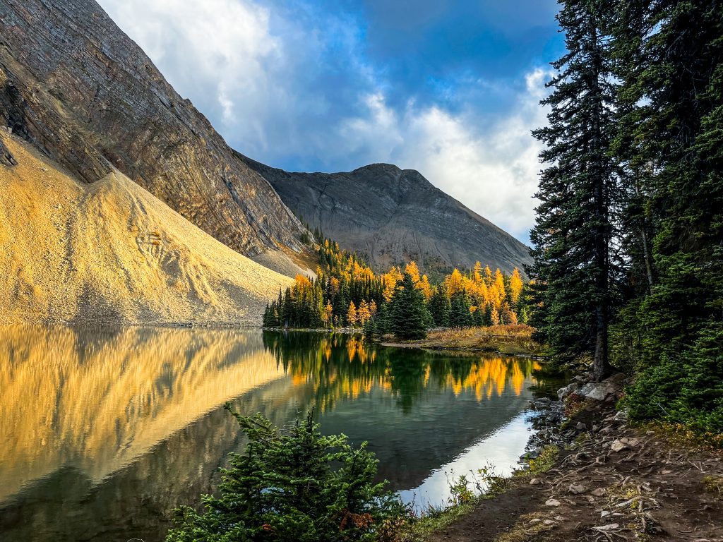 Calm Chester Lake reflecting golden larches and surrounding mountains 