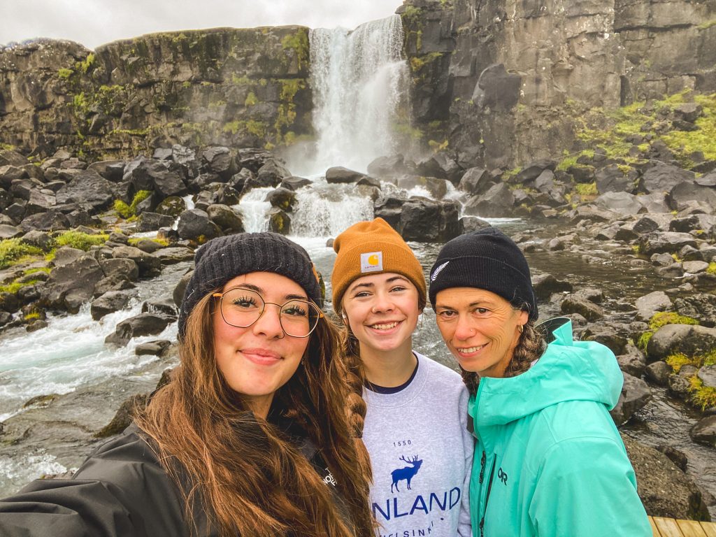 Three hikers posing in front of Öxarárfoss Falls:  the first Golden Circle stop found in Iceland's Þingvellir National Park.