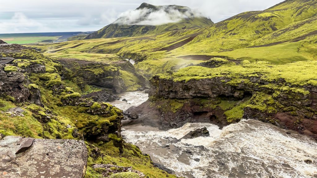 Fast-moving Skógá River carving through a moss-covered volcanic canyon along the Fimmvörðuháls trail.