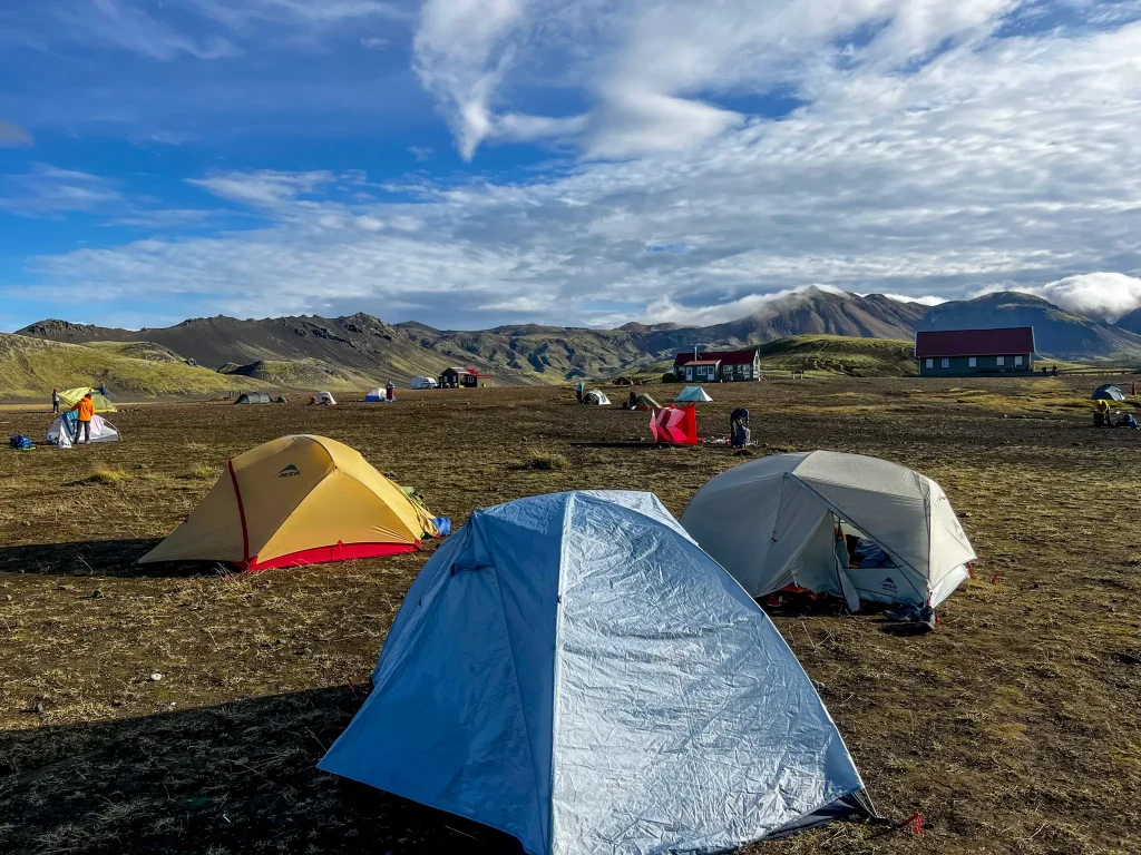 Camping on the Laugavegur Tents set up in the open campground at Álftavatn on the Laugavegur Trail, with surrounding mountains and no designated tent sites.