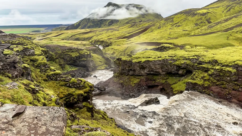 Fast-moving Skógá River carving through a moss-covered volcanic canyon along the Fimmvörðuháls trail.