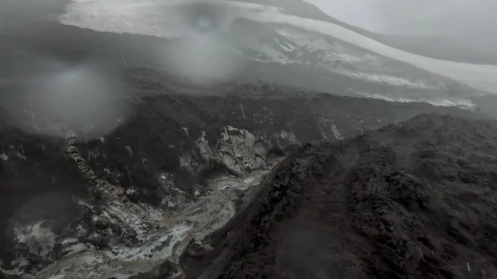 Hikers on the Fimmvörðuháls extension of the Laugavegur Trail overlooking a lush green canyon in Iceland's highlands