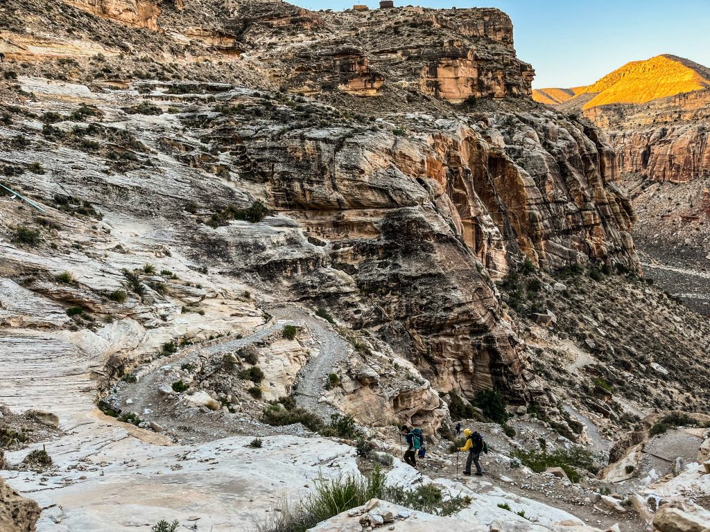 Two hikers following the hardest part of the Havasupai trail down the switchbacks into the canyon