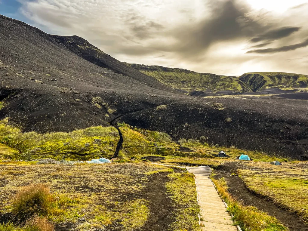 Trail leaving Emstrur camp with boardwalks crossing mossy terrain and volcanic hills in the highlands