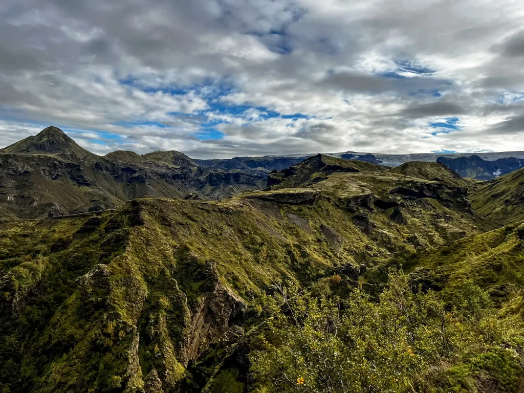 Open ridgelines and layered green mountains on Fimmvörðuháls under dramatic Icelandic skies