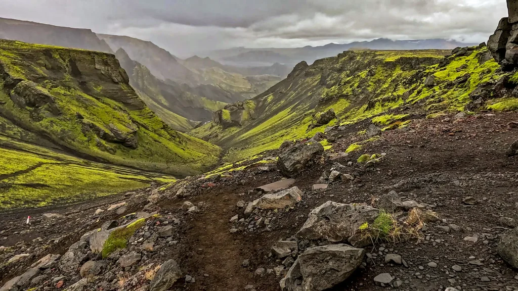 Exposed section of the Fimmvörðuháls extension of the Laugavegur Trail overlooking a dramatic moss-covered valley.