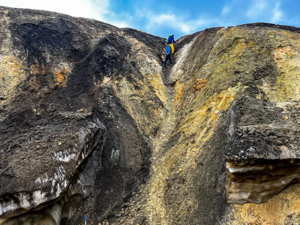 Backpacker carefully descending a very steep, loose volcanic chute between Landmannalaugar and Hrafntinnusker