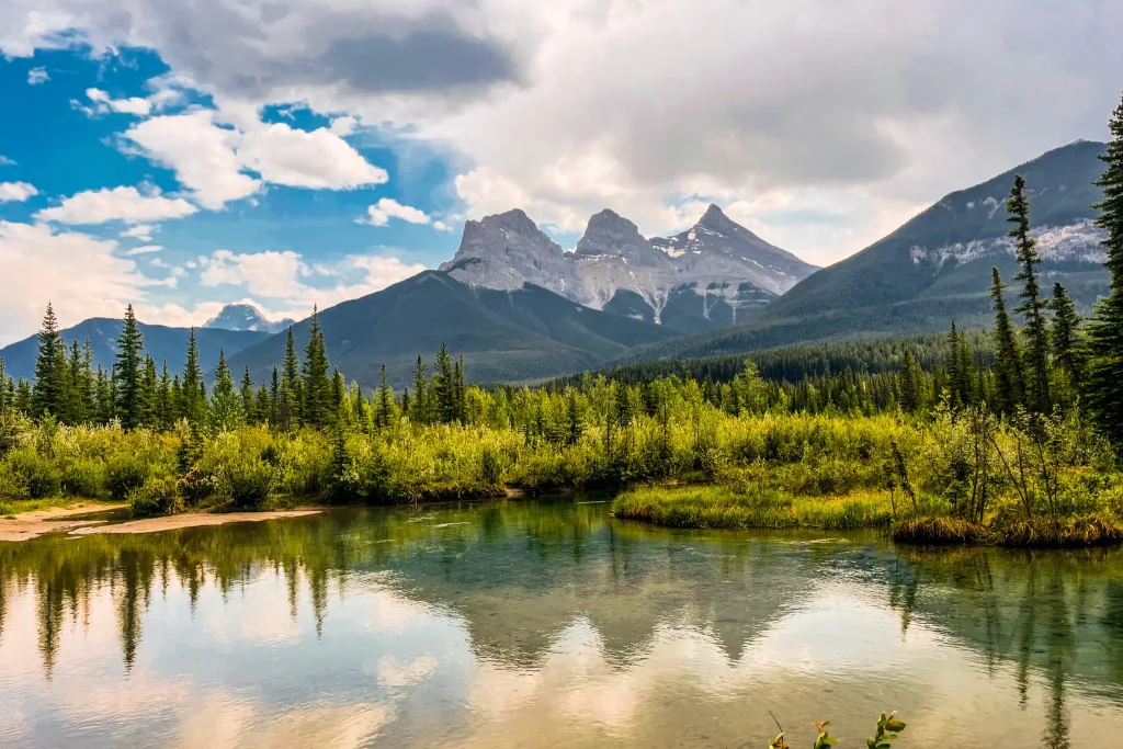 Thee Sisters mountain view reflected in a pond near Canmore