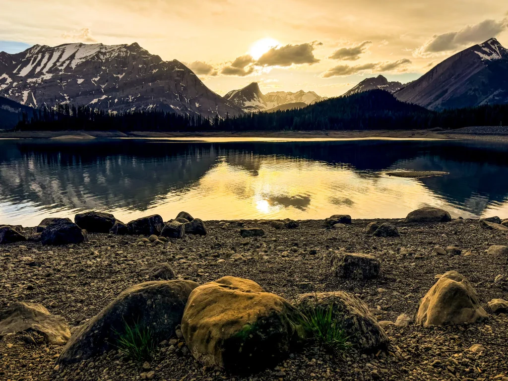 Sunset reflections on Upper Kananaskis Lake surrounded by mountain peaks