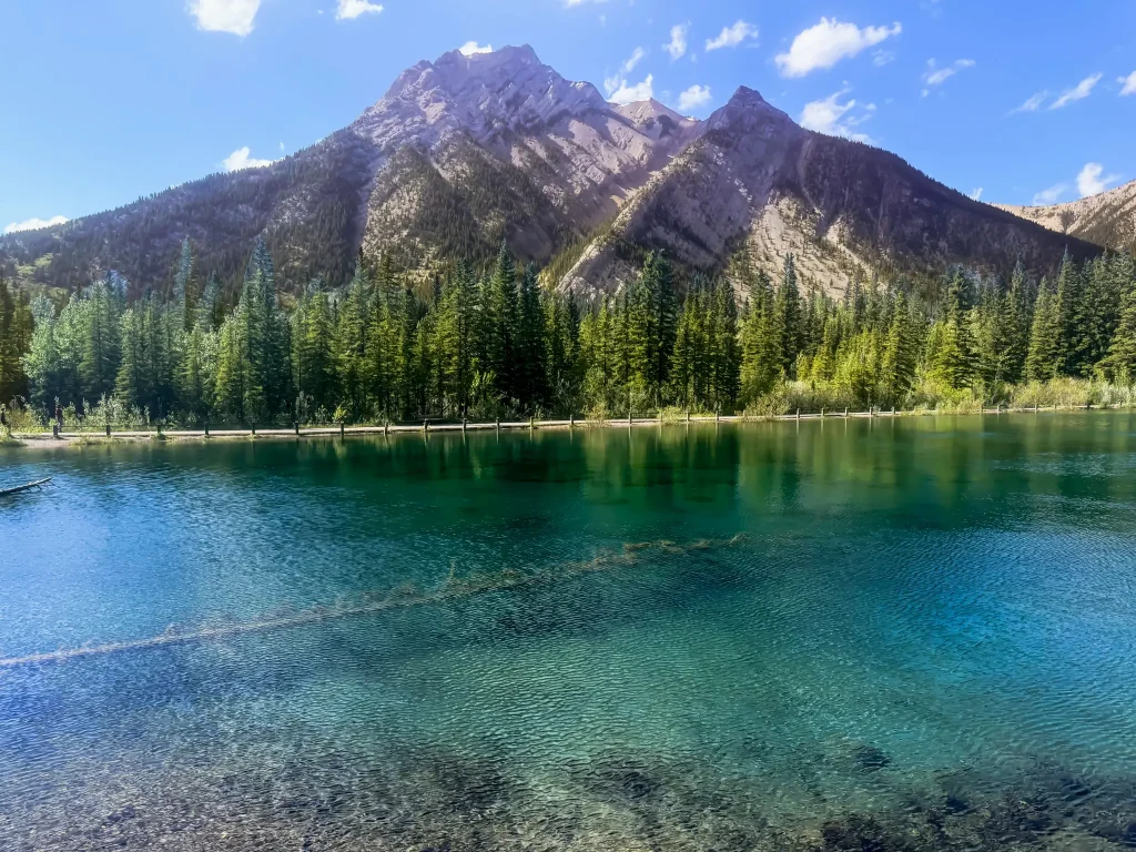 Mount Lorette Ponds with clear water reflecting mountains and evergreen forest