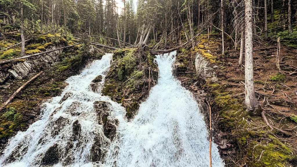 Twin cascades of Sarrail Falls flowing through a forested ravine near Rawson Lake