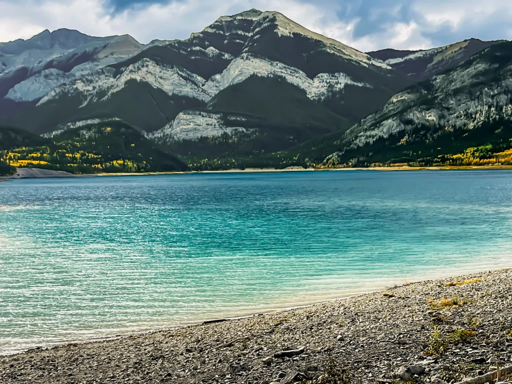 Turquoise water and mountains along the shore of Barrier Dam in Kananaskis