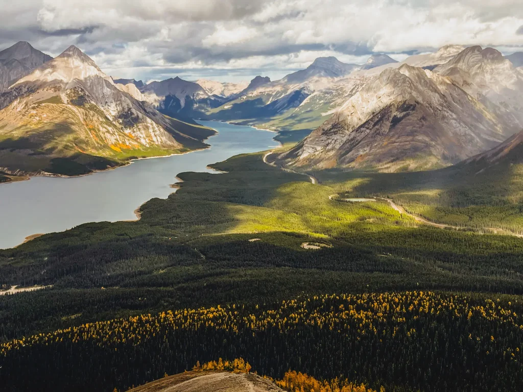 View of golden larches, Spray Lakes Reservoir and mountains from atop Tent Ridge.